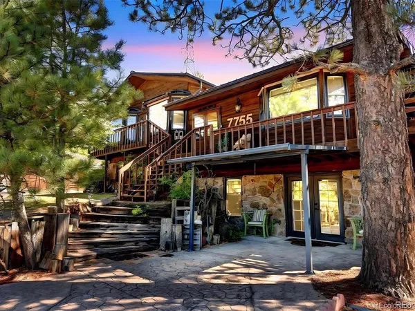 a view of a house with a porch and a large tree
