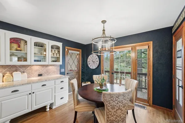 a dining room with furniture a chandelier and wooden floor