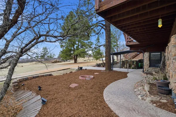 a view of a patio with a table chairs and a yard