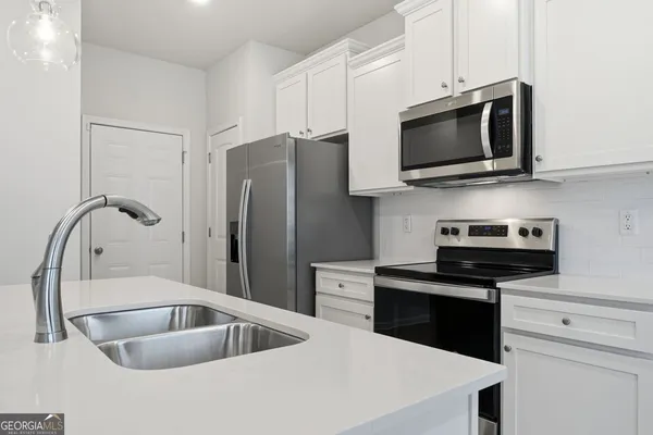 a kitchen with stainless steel appliances a sink a stove and microwave