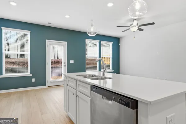 a very nice looking hall with a sink and dishwasher with wooden floor