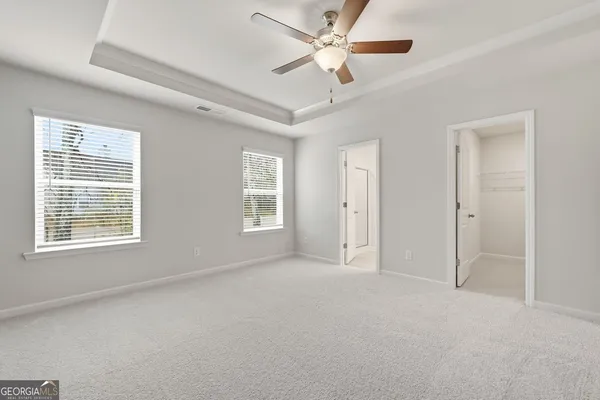 an empty room with closet and fan
