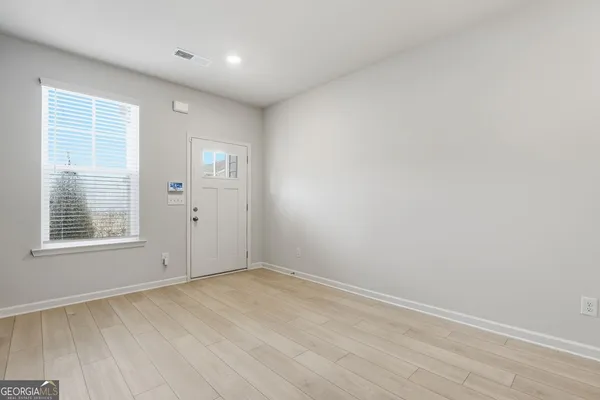 an empty room with wooden floor and windows