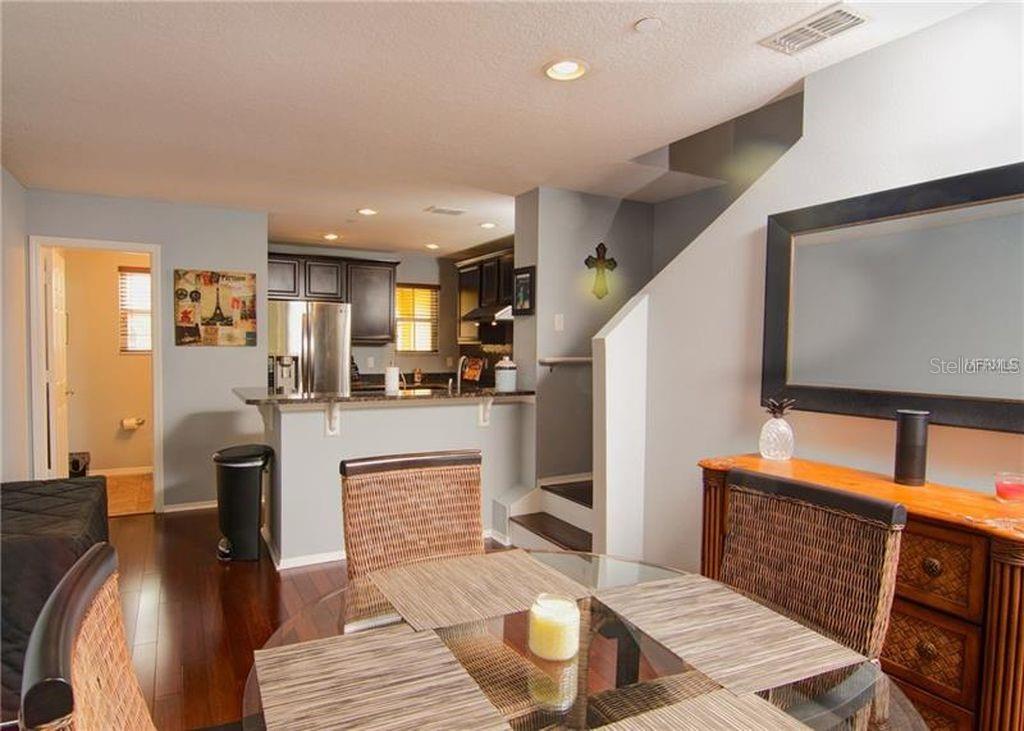 8946 White Sage Loop Lakewood Ranch, FL 34202 - Photo 6 of 36 a living room with stainless steel appliances furniture a fireplace a flat screen tv and a kitchen view