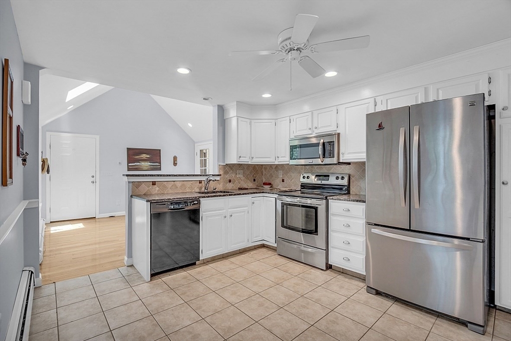 89 Kingswear Circle Dennis, MA 02660 - Photo 28 of 40 a kitchen with white cabinets stainless steel appliances and a refrigerator