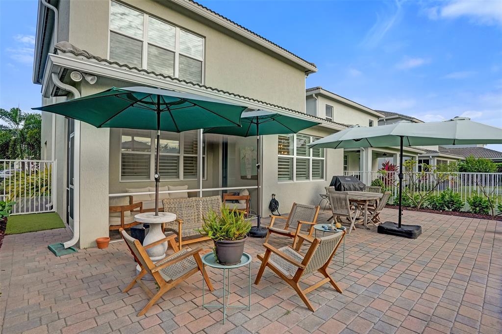 1612 Trailhead Terrace Hollywood, FL 33021 - Photo 54 of 71 a patio with a table and chairs under an umbrella