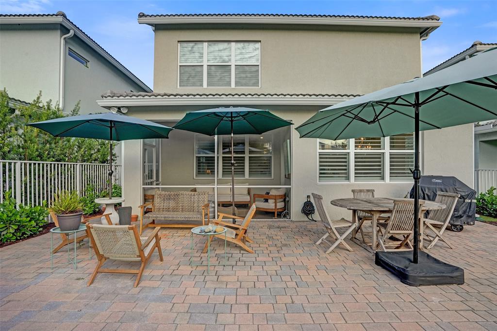 1612 Trailhead Terrace Hollywood, FL 33021 - Photo 55 of 71 a patio with a table and chairs under an umbrella
