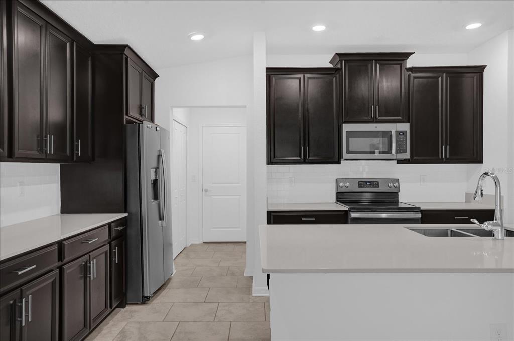 4712 Magnetite Loop Mount Mount Dora, FL 32757 - Photo 5 of 15 a kitchen with granite countertop stainless steel appliances and refrigerator