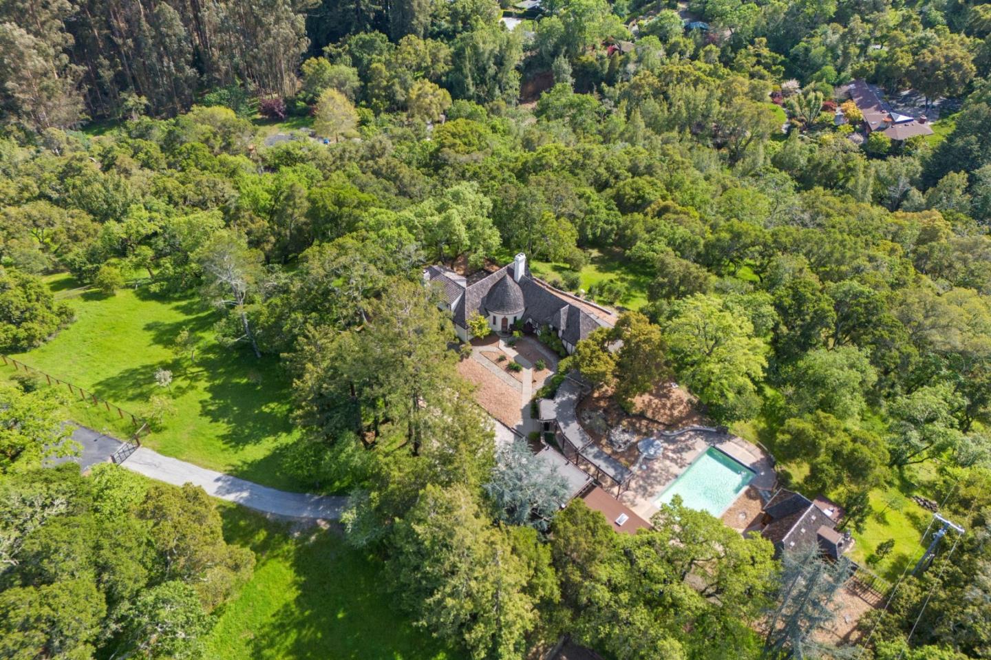 an aerial view of residential house with outdoor space and trees all around