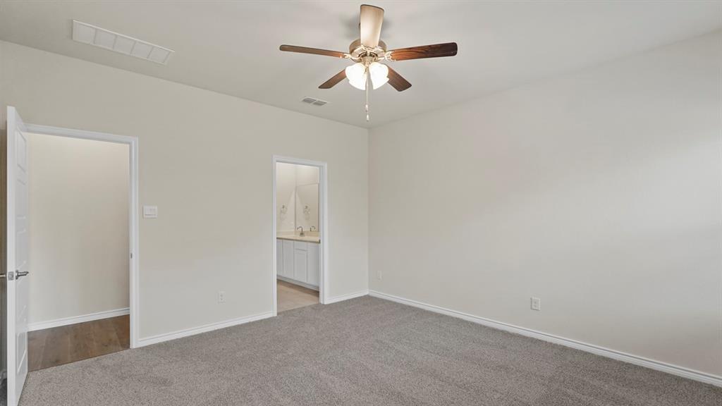 447 Epiphany Lane Lavon, TX 75166 - Photo 16 of 31 Spacious bedroom featuring neutral carpeting, light-colored walls, and a ceiling fan