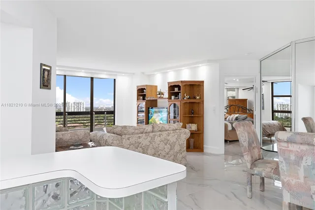 a bedroom with a bed couches and a flat tv screen