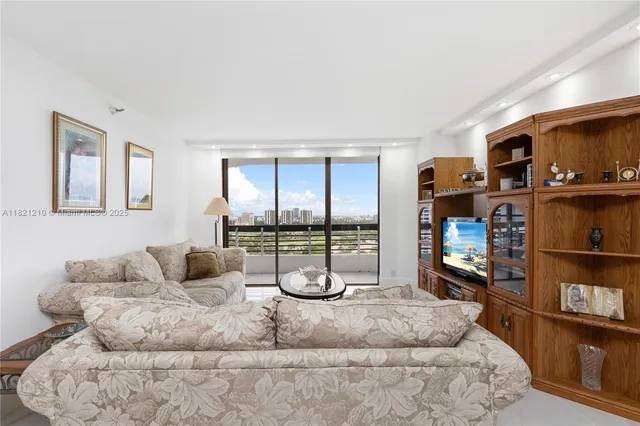 a living room with furniture a flat screen tv and a floor to ceiling window or shelf