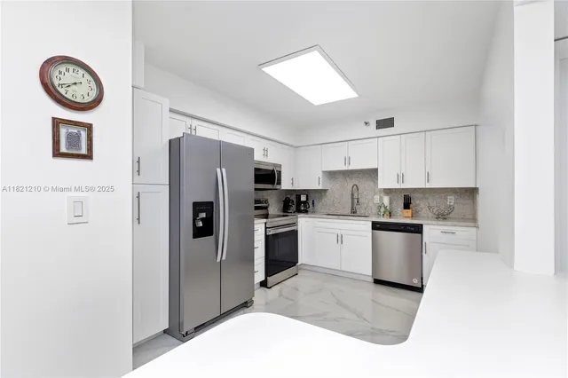 a kitchen with stainless steel appliances granite countertop a refrigerator and a stove