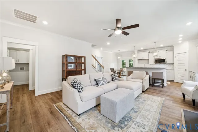 a living room with furniture and a wooden floor