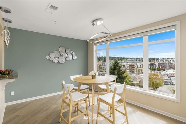 a dining room with furniture a large window and wooden floor