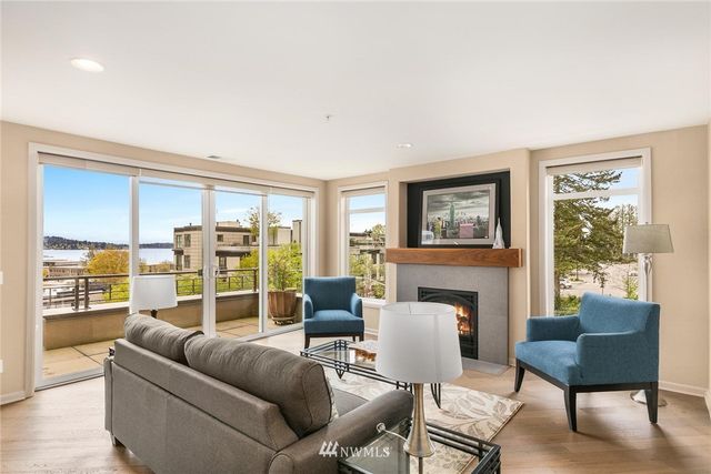 a living room with furniture a fireplace and a large window