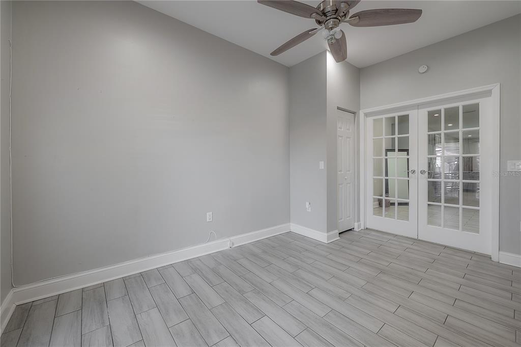 2341 West Chestnut Street Tampa, FL 33607 - Photo 30 of 42 an empty room with wooden floor chandelier fan and windows