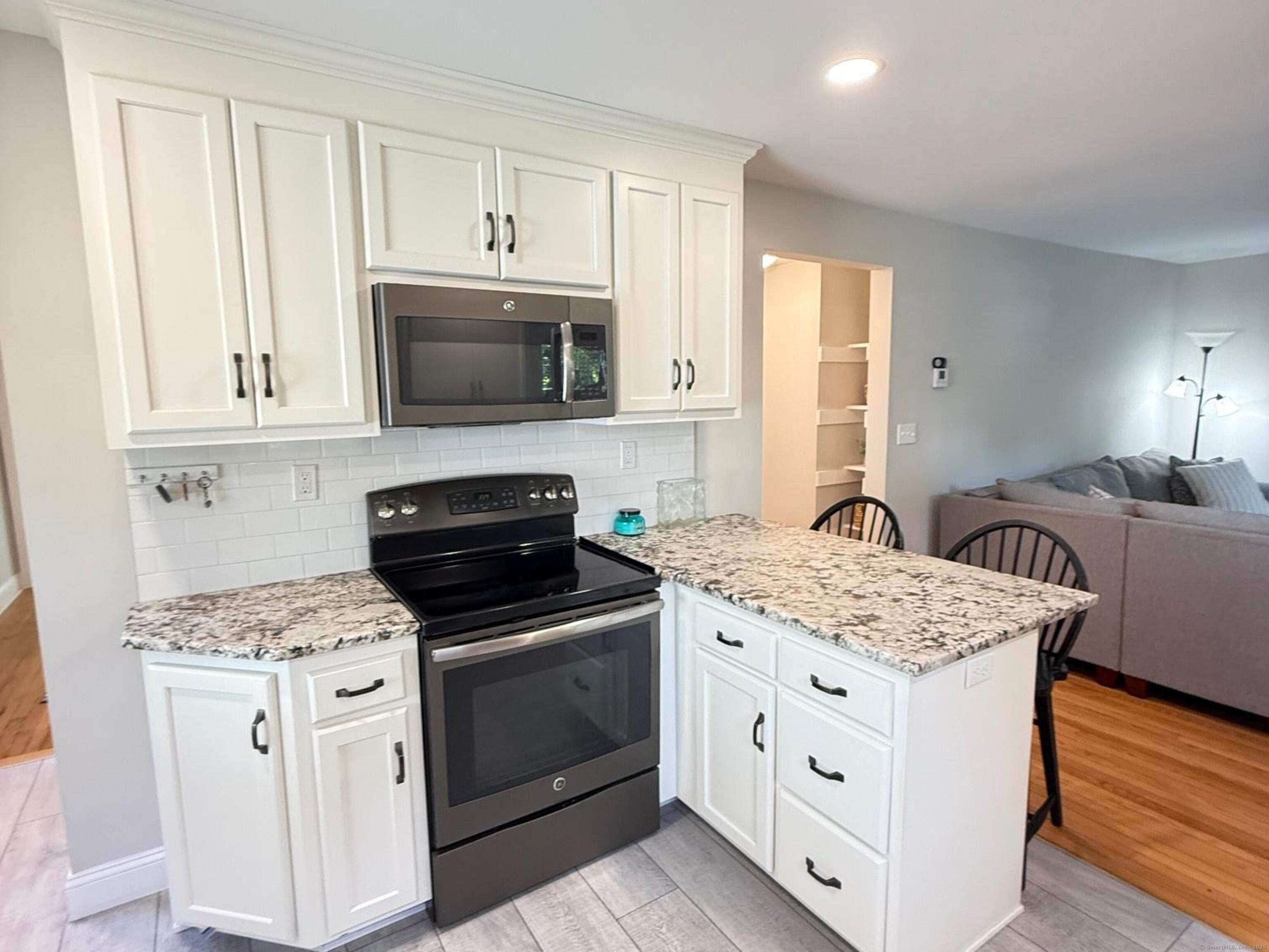 152 Hewitt Road Stonington, CT 06355 - Photo 11 of 34 a kitchen with white cabinets and appliances