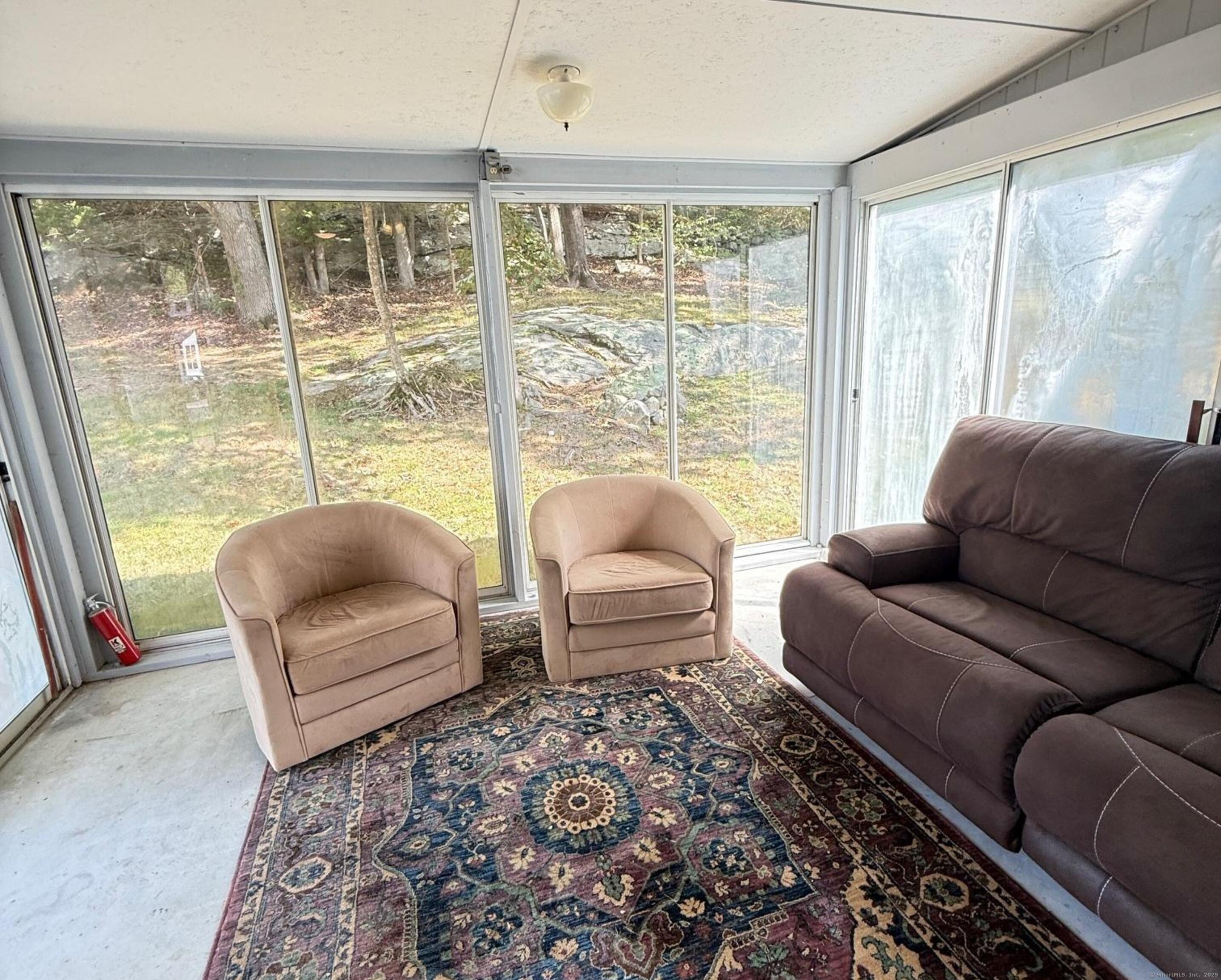 152 Hewitt Road Stonington, CT 06355 - Photo 15 of 34 a living room with furniture and a floor to ceiling window