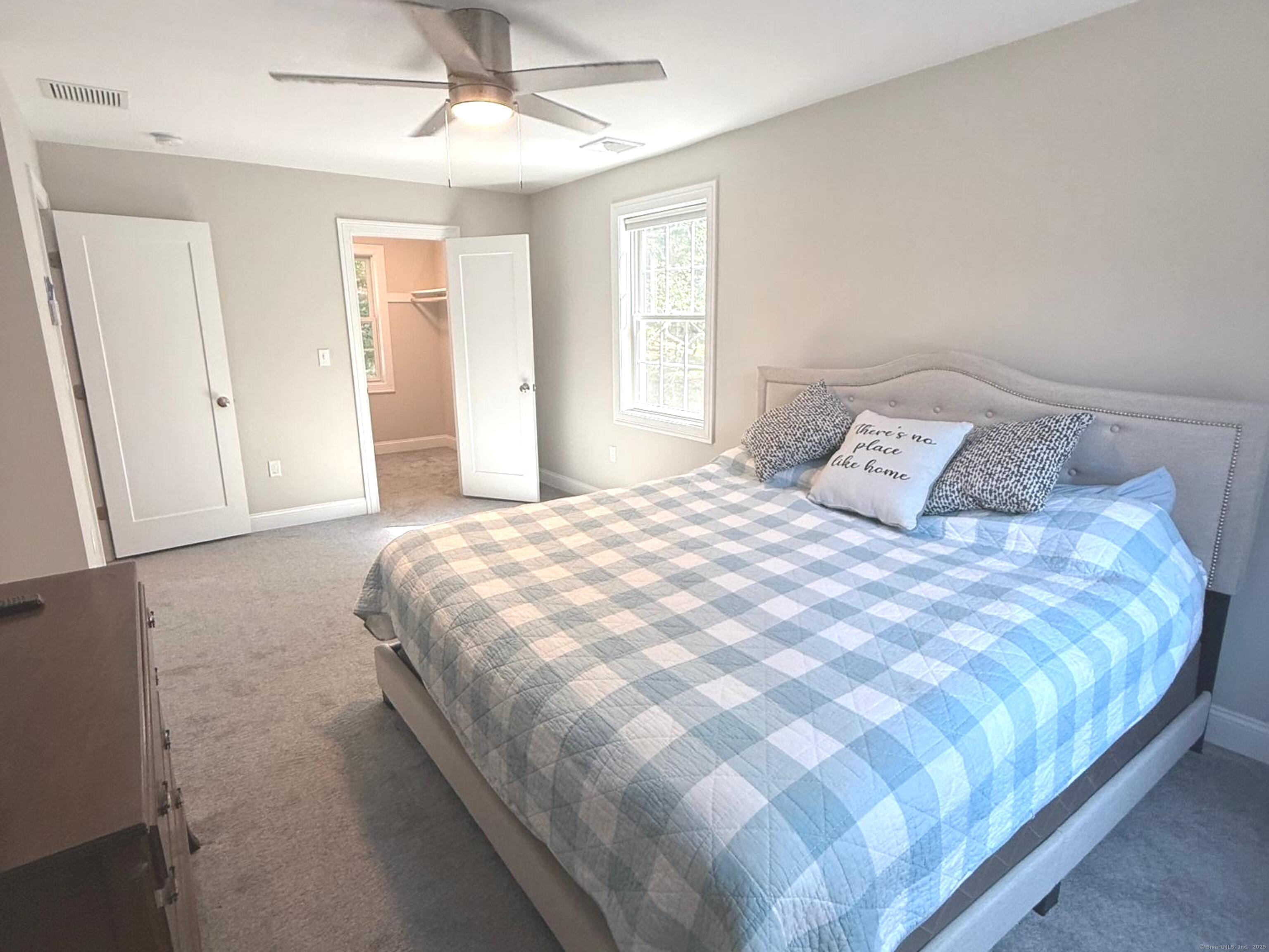 152 Hewitt Road Stonington, CT 06355 - Photo 21 of 34 a large bed sitting in a bedroom next to a window and a chandelier