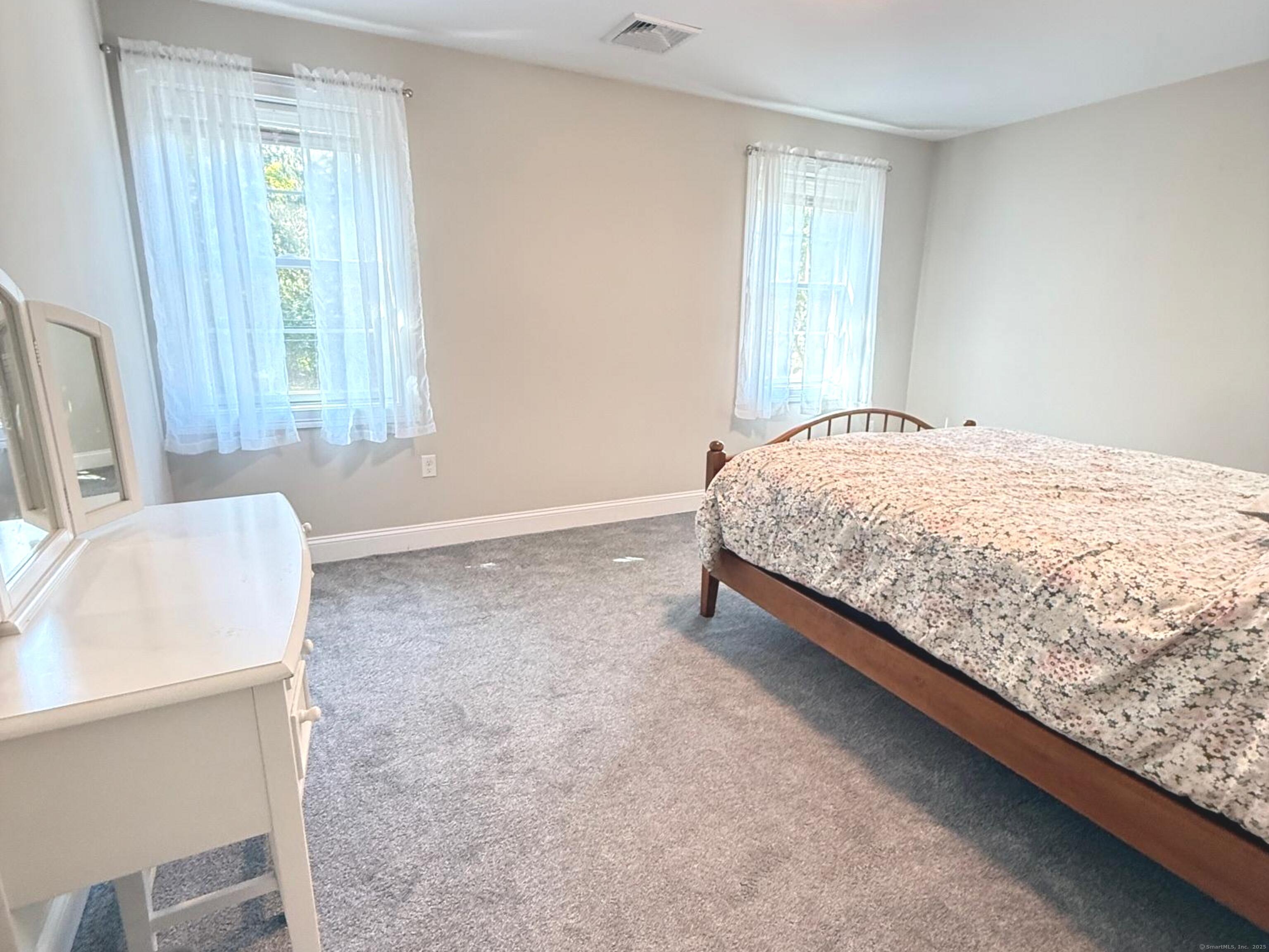 152 Hewitt Road Stonington, CT 06355 - Photo 29 of 34 a bed sitting in a bedroom next to a window