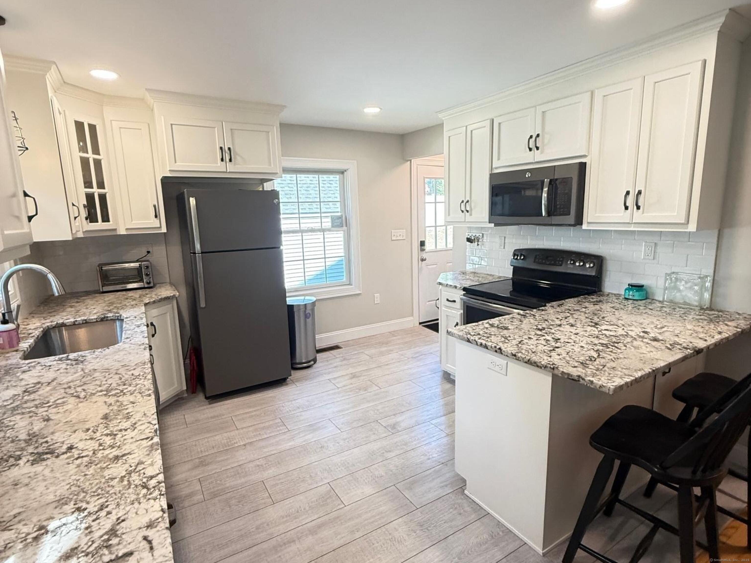 152 Hewitt Road Stonington, CT 06355 - Photo 8 of 34 a kitchen with a refrigerator a stove a sink and a microwave