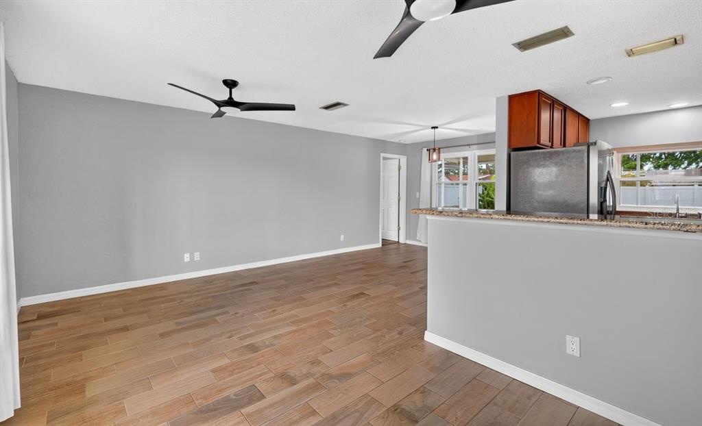 1309 Suwanee Road Daytona Beach, FL 32114 - Photo 6 of 33 a view of a big room with wooden floor and a ceiling fan