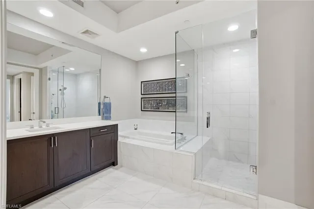 a bathroom with a tub a sink shower and mirror