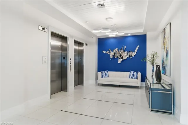 a spacious bedroom with a large bed and a chandelier