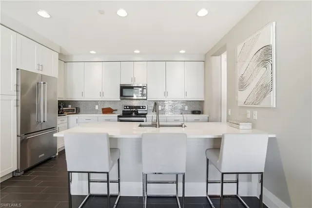 a kitchen with stainless steel appliances a refrigerator stove microwave and cabinets