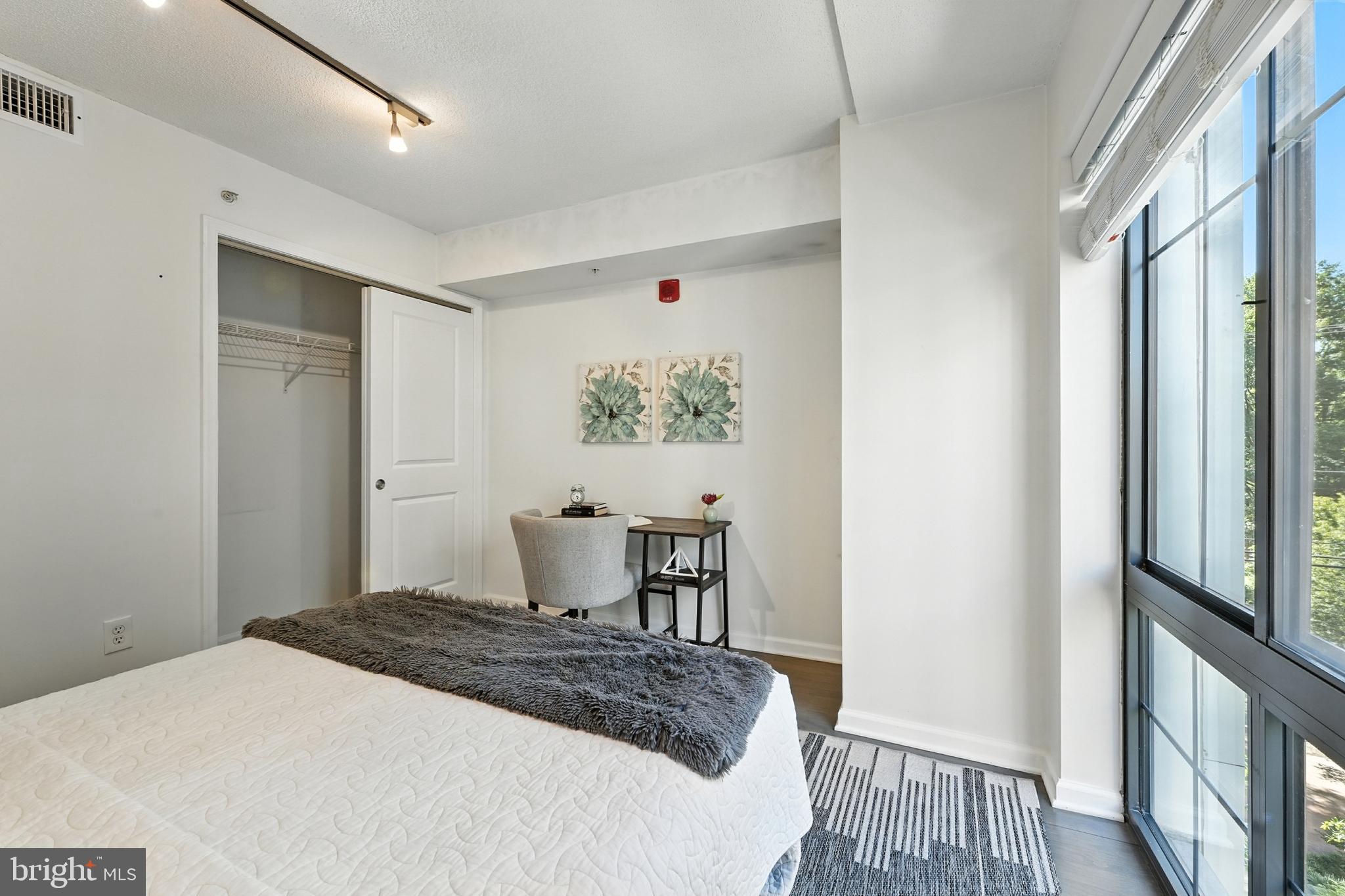 7923 Eastern Avenue Northwest, Unit 303 Silver Spring, MD 20910 - Photo 17 of 38 a bedroom with a bed and a table