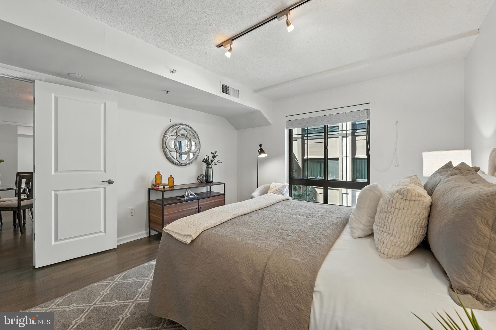 7923 Eastern Avenue Northwest, Unit 303 Silver Spring, MD 20910 - Photo 23 of 38 a bedroom with a bed and a large window