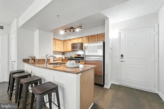 a kitchen with kitchen island a sink stove and refrigerator