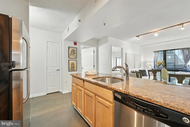 a kitchen with granite countertop a sink and refrigerator