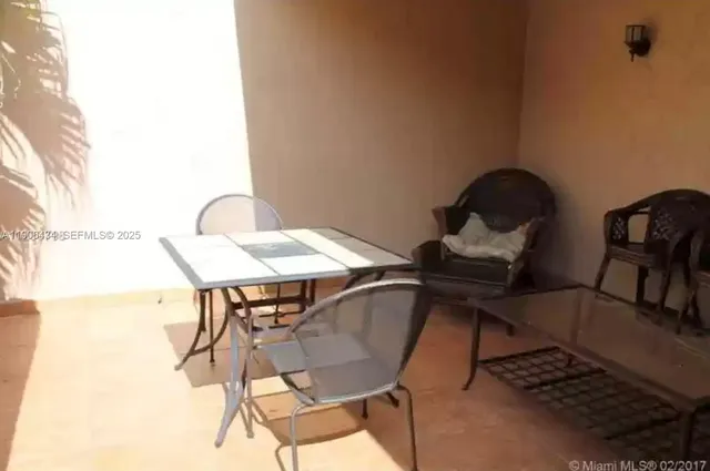 a view of a porch with chairs and backyard