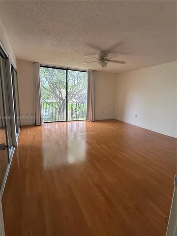 a view of a room with wooden floor and large window