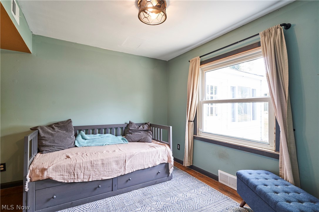 780 Bates Road Rocky River, OH 44116 - Photo 20 of 35 Room featuring a double-hung window with dark trim, a decorative ceiling light fixture, and light green wall paint