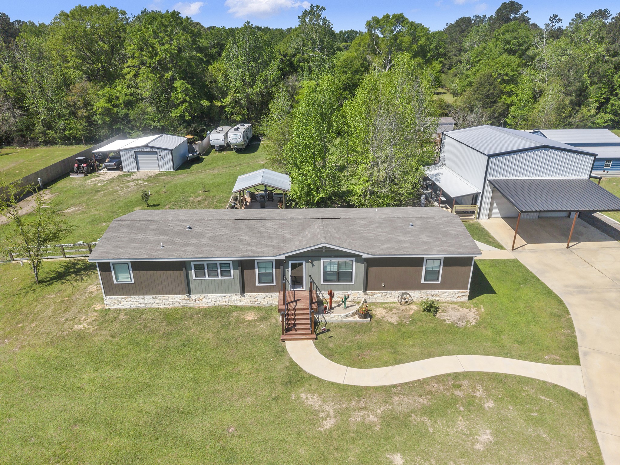 Beautiful 2022 Double Wide on a Slab with Patio & 2 Shops