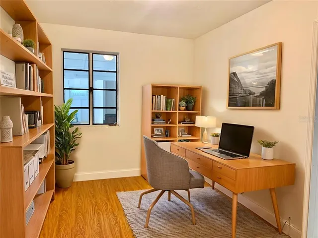 a view of a workspace with furniture and a bookshelf