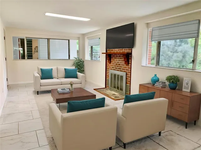 a living room with furniture a flat screen tv and a large window