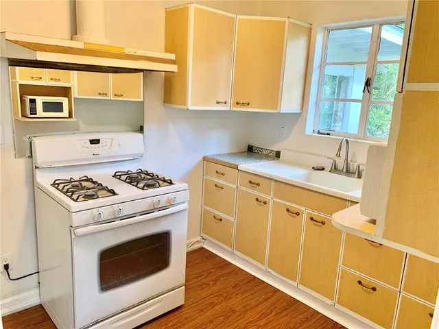 a kitchen with a stove a sink and a microwave