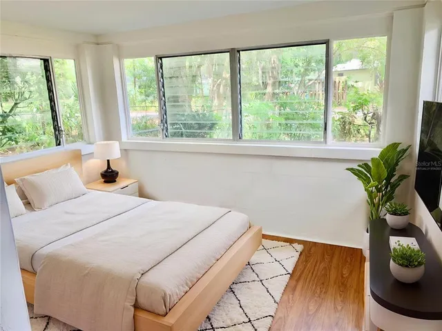 a bedroom with a bed and a potted plant