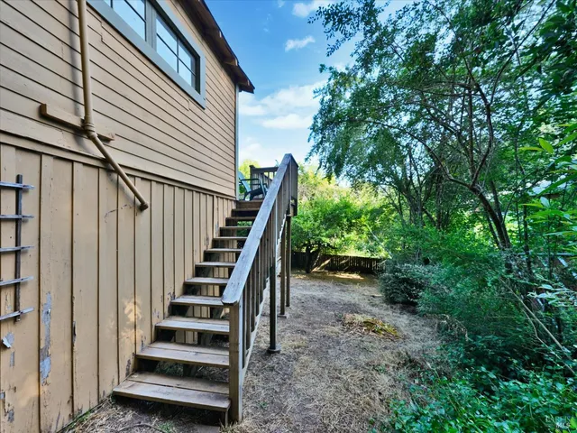 a view of backyard with small cabin and wooden fencing