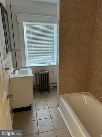 a white toilet sitting next to a white sink and vanity