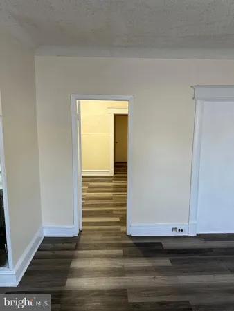 a view of a hallway with wooden floor and entryway