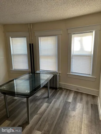 a view of a room with wooden floor and a window