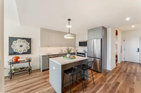 a view of a kitchen with a sink and refrigerator