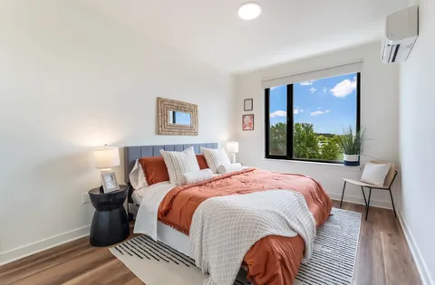 a bed sitting in a bedroom next to a window