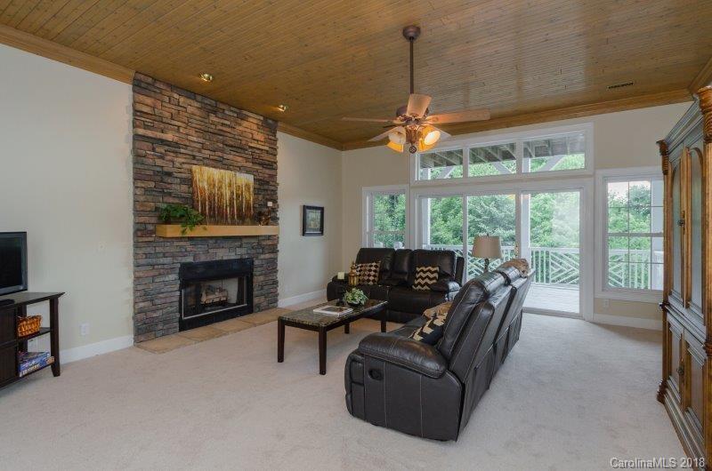 105 Spring Path, Unit 77 Hendersonville, NC 28739 - Photo 17 of 21 a living room with furniture a fireplace and a flat screen tv