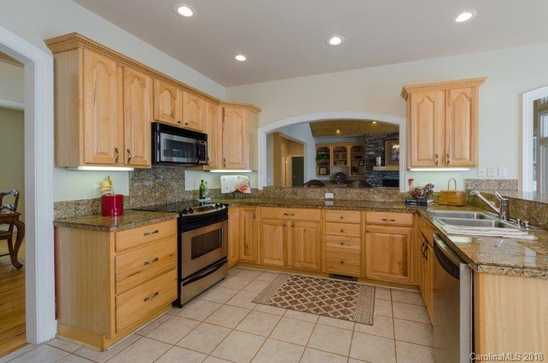 105 Spring Path, Unit 77 Hendersonville, NC 28739 - Photo 9 of 21 a kitchen with stainless steel appliances granite countertop a sink and dishwasher a stove top oven with wooden floor